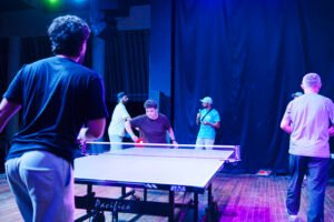 Engaging table tennis tournament at Beach & Beyond 8 event, showcasing competitive players and lively atmosphere. Perfect for sports enthusiasts and community engagement.