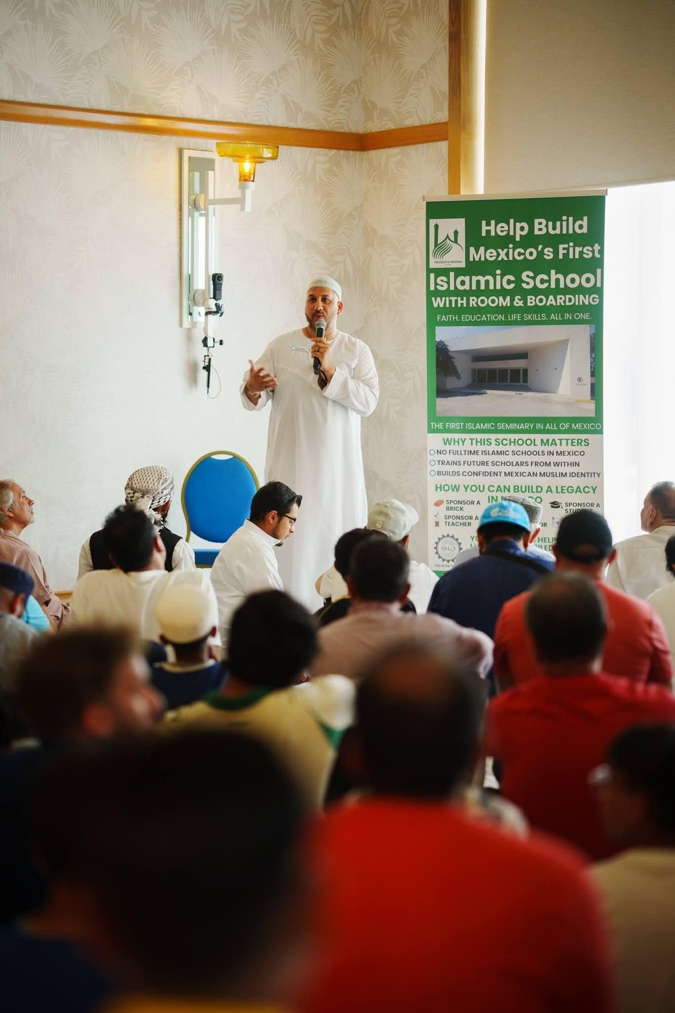 An inspiring speaker addresses a diverse audience at the Husna Experience event, promoting community engagement and educational initiatives.