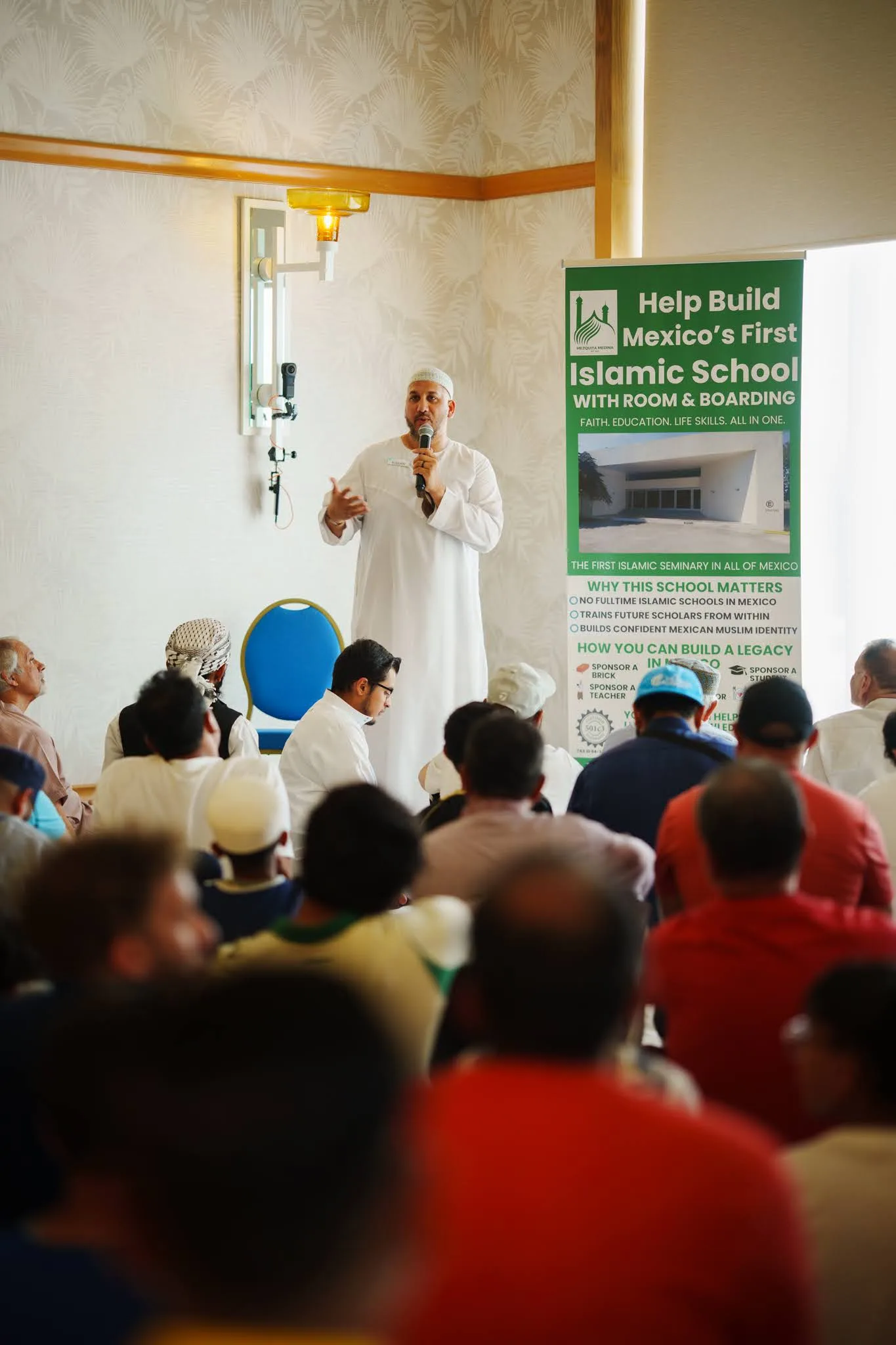 An inspiring speaker addresses a diverse audience at the Husna Experience event, promoting community engagement and educational initiatives.